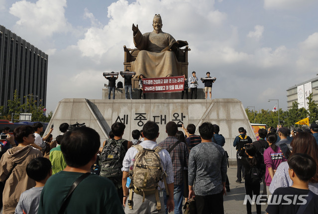 【서울=뉴시스】최동준 기자 = 한국대학생진보연합이 4일 서울 광화문광장 세종대왕 동상에 올라 지소미아 파기 방해, 방위비 분담금 인상 압박 등을 주장하며 미국 규탄 기습시위를 하고 있다. 2019.10.04. photocdj@newsis.com