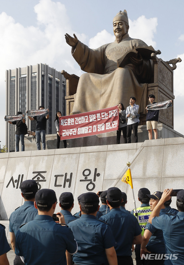 【서울=뉴시스】최동준 기자 = 한국대학생진보연합이 지난 4일 서울 광화문광장 세종대왕 동상에 올라 지소미아 파기 방해, 방위비 분담금 인상 압박 등을 주장하며 미국 규탄 기습시위를 하고 있다. 2019.10.04. photocdj@newsis.com