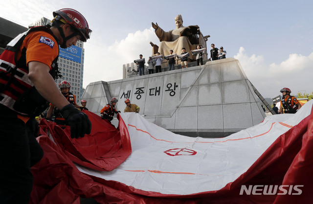 【서울=뉴시스】최동준 기자 = 한국대학생진보연합이 4일 서울 광화문광장 세종대왕 동상에 올라 지소미아 파기 방해, 방위비 분담금 인상 압박 등을 주장하며 미국 규탄 기습시위를 하자 소방대원이 추락 사고에 대비해 안전 장비를 설치하고 있다. 2019.10.04. photocdj@newsis.com