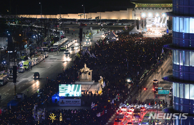 【서울=뉴시스】김선웅 기자 = 헌법재판소가 박근혜 전 대통령에 대한 탄핵을 인용 결정한 2017년 3월 10일 오후 서울 종로구 광화문광장 일대에서 열린 탄핵축하 촛불집회에서 시민들이 촛불을 들고 환호하고 있다. 2019.10.09. mangusta@newsis.com