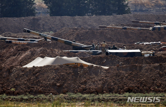【터키-시리아 접경지역=AP/뉴시스】시리아와 국경을 맞대고 있는 터키 산리우파주 접경 지역에 배치된 터키군 포대에 8일 터키 군인들의 모습이 보이고 있다. 터키는 시리아와 관련해 미국의 위협에 굴복하지 않을 것이라고 푸아트 옥타이 터키 부통령이 8일 밝혔다. 이는 하루 전 시리아 북부에 대한 터키의 침공 규모에 대한 도널드 트럼프 미 대통령의 경고에 대한 대응이다. 2019.10.8