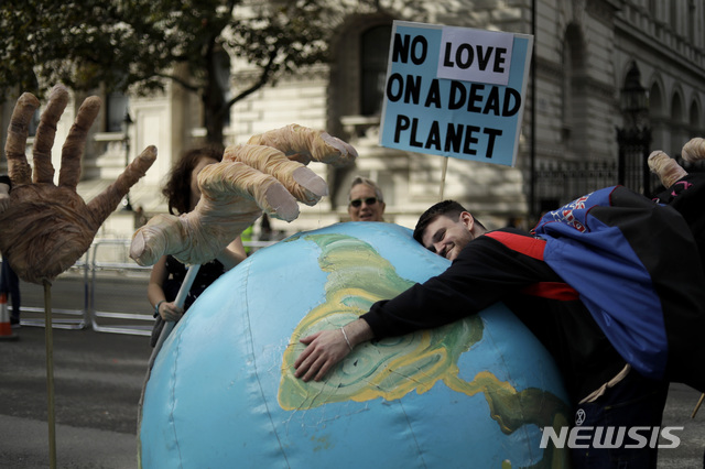 [ 런던= AP/뉴시스] 지난 해 런던 중심가의 기후변화 시위에서 지구 모형을 끌어안고 있는 영국의 기후변화 행동 시위대원.&nbsp; 환경단체들은 4월 22일의 '지구의 날'행진에 이어 해마다 가을에는 기후변화를 위핸 전 세계의 시위와 행진을 이어왔다.&nbsp;&nbsp;&nbsp;&nbsp;&nbsp; 