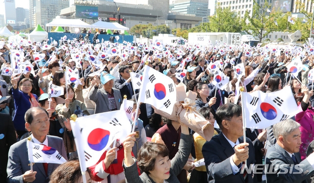 【서울=뉴시스】 전진환 기자 = 제573돌 한글날 경축식이 열린 9일 오전 서울 광화문광장에서 참석자들이 태극기를 들고 만세삼창을 하고 있다. 2019.10.09.   amin2@newsis.com