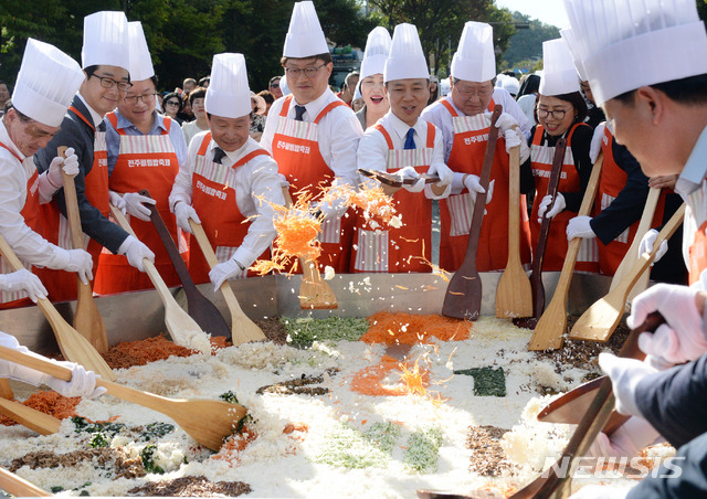 【전주=뉴시스】 김얼 기자= 2019 전주비빔밥축제가 개막한 9일 전북 전주시 국립무형유산원 앞 전주천서로에서 전주시 35개 동 주민들과 함께 비빔밥을 비비는 '3355 우리 동네 비빔밥' 퍼포먼스가 실시된 가운데 김승수 전주시장과 최용범 전라북도 행정부지사, 송성환 전라북도의회 의장을 비롯한 시민과 관계자들이 대형 비빔밥을 비비며 환하게 웃고 있다. 2019.10.09.pmkeul@newsis.com