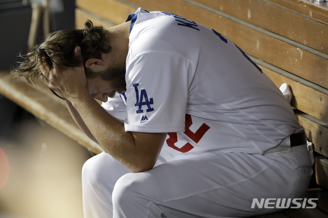 【로스엔젤레스=AP/뉴시스】 LA다저스의 클레이튼 커쇼가 10일(한국시간) 미국 캘리포니아주 로스앤젤레스 다저 스타디움에서 워싱턴 내셔널즈를 상대로 열린 2019 미국메이저리그(MLB) 내셔널리그 디비전시리즈(NLDS) 5차전에 불펜으로 등판했다가 8회초 앤서니 랜던과 후안 소토에게 백투백 홈런을 허용한 뒤 강판당해 덕아웃에서 머리를 감싸쥐고 있다. 앤서니 랜던에 이은 후안 소토의 백투백 홈런으로 점수는 3-3 동점이 됐다. 다저스는 결국 연장 10회초 조 켈리가 켄드릭에게 만루홈런을 내주며 챔피언십 진출에 실패했다. 