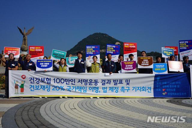 【서울=뉴시스】의료민영화 저지와 무상의료 실현을 위한 운동본부와 민주노총이 11일 청와대 분수대 앞에서 '건강보험 100만인 서명운동 결과'를 발표하고 '건보재정 20% 국가책임 이행, 법 제정 촉구' 기자회견을 하고 있다. 2019.10.11. (사진=무상의료운동본부 제공) photo@newsis.com