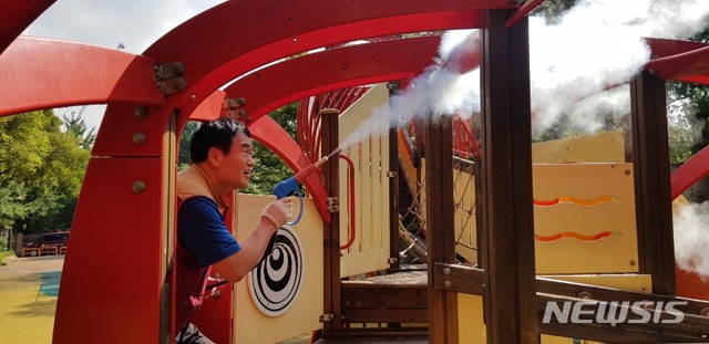 【서울=뉴시스】 대방동에 위치한 참새어린이공원 놀이시설에 고온스팀으로 살균·소독을 하고 있는 모습. 2019.10.11. (사진=동작구 제공)