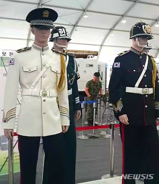 【서울=뉴시스】김성진 기자 = 지난 4~7일 계룡대에서 열린 육군 지상군 페스티벌에 전시된 새 헌병 복장 시제품. 고려시대 투구 디자인과 대한제국 시기 의복을 본뜬 듯한 복장이 적용된 헌병 행사복(오른쪽), 정모 형태의 새 군모와 하얀색 계열의 상의가 적용된 행사복(왼쪽)이 기존 헌병 의복(가운데 뒤)과 함께 전시돼 있다. 2019.10.13. (사진 = 군사동아리 '팀 더 37벙커' 제공 영상 캡처) ksj87@newsis.com