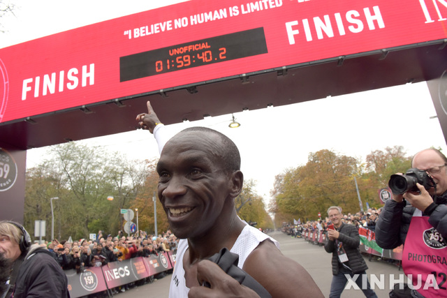 [빈(오스트리아)=신화/뉴시스] 2019년 10월 12일(현지시간) 오스트리아 빈의 프라터 파크에서 'INEOS 1:59 챌린지'가 열려 엘리우드 킵초게(케냐)가 1시간59분40.2초로 결승선을 통과한 후 기록판을 가리키며 포즈를 취하고 있다.다만 킵초게는 '7인 1조'로 달리며 페이스메이커의 도움을 받았고 앞서 달리는 차량이 레이저로 '속도 조절'을 도와 국제육상경기연맹(IAAF)은 "이 기록을 공인하지는 않을 것"이라고 밝혔다.킵초게는 '2018 베를린 국제마라톤'에서 42.195㎞를 2:01:39초로 달려 세계 기록을 보유하고 있으며 이번 1:59 챌린지의 결과로 마라톤 풀코스를 2시간 이내에 완주하는 것이 머지않았음을 보여주었다. 2019.10.12.