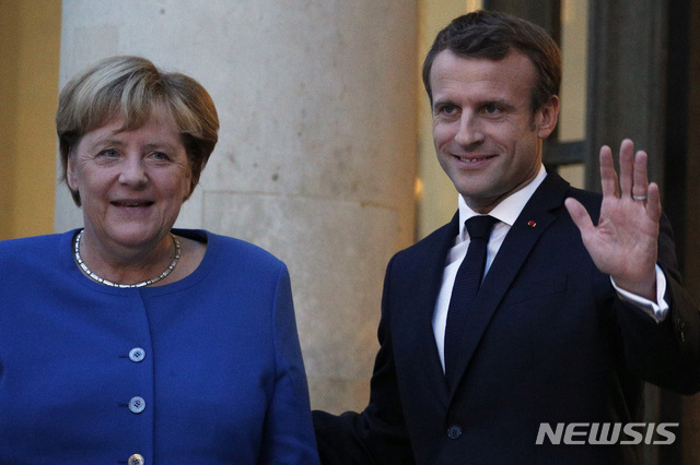 【파리= AP/뉴시스】 에마뉘엘 마크롱 프랑스 대통령이 13일 엘리제궁을 방문한 앙겔라 메르켈 독일 총리와 회담을 마친 뒤 공동성명을 발표하기 전에 인사를 하고 있다.
