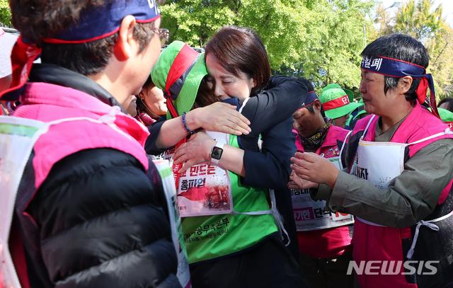 【서울=뉴시스】전신 기자 = 학교 비정규직 노동자들과 교육 당국이 임금 교섭에서 잠정적으로 합의를 이룬 15일 서울 종로구 효자치안센터 앞 전국학교비정규직연대회의(학비연대) 농성장을 방문한 유은혜 사회부총리 겸 교육부 장관이 조합원들과 면담을 마친 후 포옹하고 있다. 교육당국과 학비연대는 30일부터 보수체계 외 직종에 대한 보충교섭을 진행한다. 2019.10.15. photo1006@newsis.com