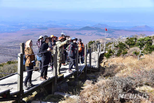 【제주=뉴시스】 한라산을 오른 탐방객들. 한라산은 이달 말이 돼야 단풍이 절정에 이를 것으로 전망된다. 한라산국립공원관리사무소는 이때에 맞춰 오는 26일 ‘한라산에서 보내는 가을편지’산행 프로그램을 운영한다. (사진=한라산국립공원관리사무소 제공)