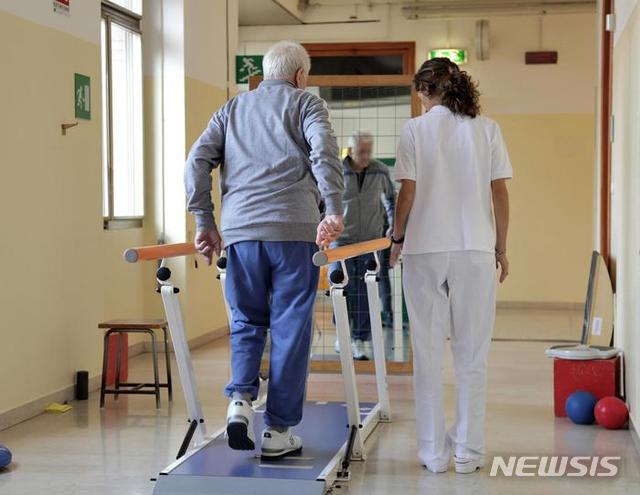 【서울=뉴시스】세계 최초로 척추뼈 이식 수술을 받은 77살의 이탈리아 남성이 물리치료를 받고 있는 모습. 이탈리아 볼로냐의 리졸리 정형외과 의료진이 세계 최초로 인간 척추뼈의 일부를 이식하는데 성공했다고 밝혔다고 이탈리아 안사 통신이 15일 보도했다. <사진출처 : 이탈리아 안사 통신> 2019.10.16