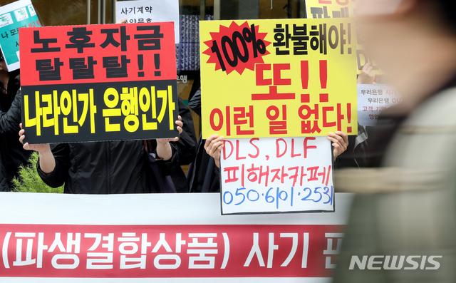 【서울=뉴시스】김병문 기자 = DLF/DLS피해자대책위원회 관계자들이 16일 오후 서울 중구 KEB하나은행 본점 앞에서 열린 우리은행·KEB하나은행 DLF(파생결합상품) 사기판매 규탄 집회에 참석해 손피켓을 들고 있다. 2019.10.16.   dadazon@newsis.com