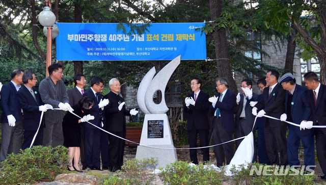 【부산=뉴시스】 하경민 기자 = 부마민주항쟁기념재단과 부산대 관계자들이 16일 오후 부산 금정구 부산대 자연과학관 옆 녹지공간에서 부마민주항쟁 40주년 기념일을 맞아 건립된 부마미주항쟁 기념 표석의 가림막을 걷어내고 있다.부마민주항쟁은 1979년 10월 16~18일 부산과 창원(마산)에서 박정희 유신독재정권에 저항해 일어난 항쟁으로, 40년 만인 올해 국가기념일로 지정됐다. 2019.10.16. yulnetphoto@newsis.com