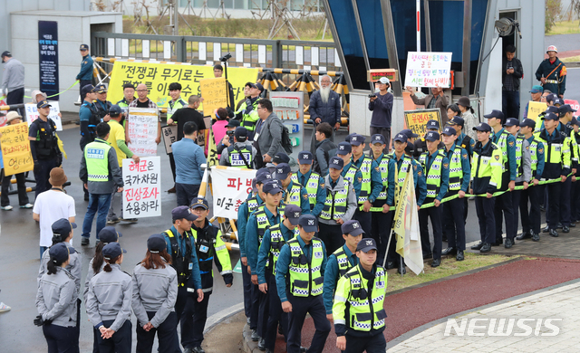 [서귀포=뉴시스]우장호 기자 = 강정마을 해군기지 반대주민회 관계자들이 18일 오전 제주 서귀포시 제주해군기지 정문 앞에서 유엔군사령부(유엔사)의 기지 방문 경위 해명을 촉구하는 기자회견을 진행 중인 가운데 경찰과 대치하고 있다. 사진은 이 사건과 관련이 없음. 2019.10.18.  woo1223@newsis.com