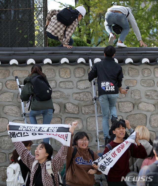 【서울=뉴시스】김선웅 기자 = 한국대학생진보연합이 18일 오후 서울 중구 주한 미국대사관저에서 방위비분담금 협상 관련 기습 농성을 하기 위해 담벼락을 넘고 있다. 2019.10.18.&nbsp; mangusta@newsis.com
