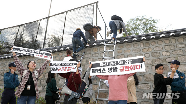 【서울=뉴시스】김선웅 기자 = 한국대학생진보연합 소속 대학생이 지난 18일 오후 서울 중구 주한 미국대사관저에서 방위비분담금 협상 관련 기습 농성을 하기 위해 담벼락을 넘고 있다. 2019.10.18. mangusta@newsis.com