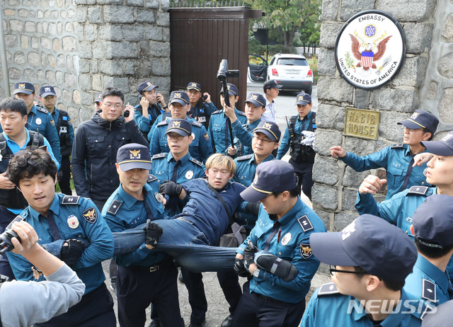 【서울=뉴시스】 전진환 기자 = 주한미군 방위비 인상을 반대하며 18일 오후 서울 중구 정동에 위치한 주한 미국대사관 관저 담장을 넘은 한국대학생진보연합 학생들을 경찰병력이 연행하고 있다. 2019.10.18. amin2@newsis.com