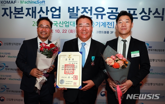 【서울=뉴시스】두산인프라코어 김인동 전무(가운데)가 22일 킨텍스에서 열린 ‘2019 한국산업대전’ 개막식에서 한국 자본재 산업 발전에 기여한 공로로 산업포장을 수상했다.