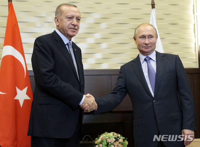 【소치=AP/뉴시스】 2019년 10월 러시아의 블라디미르 푸틴 대통령(오른쪽)이 흑해 휴양지 소치의 보차로프 루체이 별장에서 터키의 레제프 타이이프 에르도안 대통령을 만나 악수 포즈를 취하고 있다. 두 정상은 이날로 120시간의 전투 중지가 종료되는 터키의 시리아 북동부 침입전에 관해 논의했다. 러시아와 터키는 지난해 시리아 서부의 정부군 및 반군 간 휴전을 같이 중재했다. 그러나 이번 터키의 침입전 타깃인 시리아 쿠르드 무장대는 미국의 버림을 받은 뒤 시리아 정부군과 러시아에 도움을 요청한 상태다. 2019. 10. 22.
