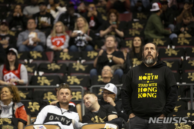 【토론토=AP/뉴시스】22일(현지시간) 캐나다 토론토에서 열린 미 프로농구(NBA) 토론토 랩터스와 뉴올리언스 펠리컨스의 개막전에서 한 팬이 홍콩 시위대를 지지하는 사람들이 나눠준 티셔츠를 입고 있다. 티셔츠에는 '홍콩과 함께 서라'고 쓰여 있다. 2019.10.23. 