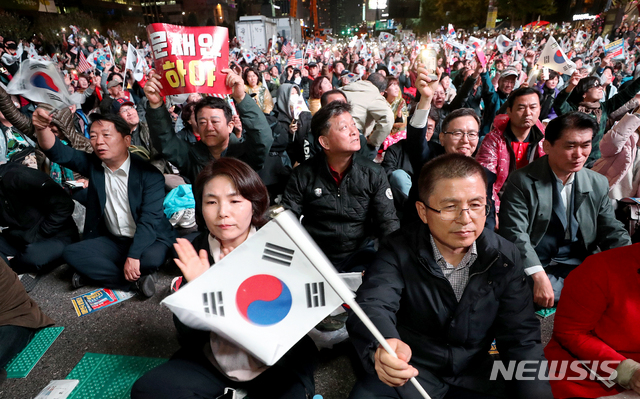 【서울=뉴시스】 김병문 기자 = 황교안 자유한국당 대표가 25일 오후 서울 종로구 광화문광장에서 문재인하야범국민투쟁본부 주최로 열린 ‘10.25 문재인 퇴진 철야 국민대회’에 참석해 태극기를 흔들고 있다. 2019.10.25. dadazon@newsis.com