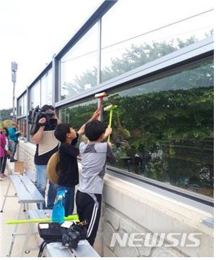 【세종=뉴시스】조류충돌 방지 스티커를 붙이고 있는 모습. 2019.10.28. (사진=환경부 제공) photo@newsis.com