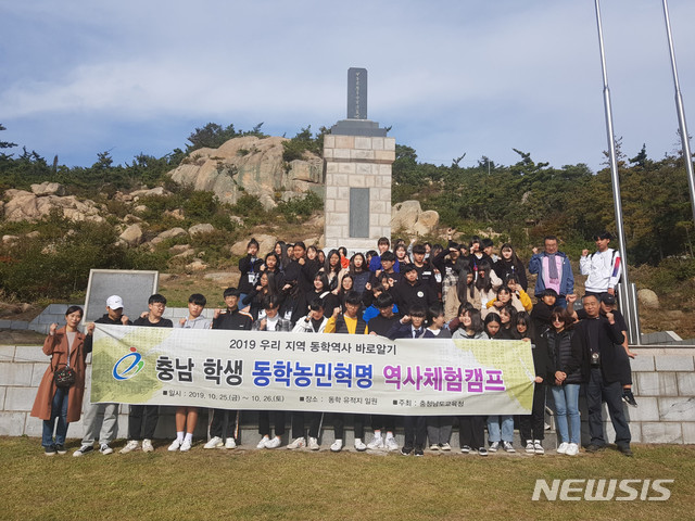 【홍성=뉴시스】충남 학생 동학농민혁명 역사체험캠프에 참가한 학생들이 태안군 백화산 교장바위 앞 동학농민혁명군 추모위령탑에서 기념촬영을 하고 있다. 
