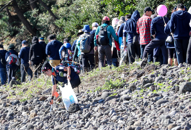 [서귀포=뉴시스] 제주 서귀포시 대포동 약천사에서 열린 제주올레걷기축제에서 한 올레꾼이 올레 8코스에 떨어진 쓰레기를 줍고 있다. (사진=뉴시스 DB). photo@newsis.com 