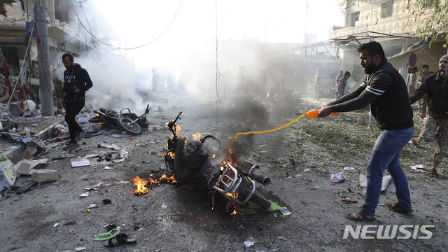 【탈 아비아드(시리아)=AP/뉴시스】터키 북동부 탈 아비아드 마을에서 2일 한 남성이 자동차 폭탄이 터진 사고 현장에서 불을 끄고 있다. 이 폭발로 13명이 숨졌다. 탈 아비아드는 쿠르드 무장세력이 통제하고 있었지만 지난달 터키의 지원을 받는 시리아 반군이 쿠르드족으로부터 통제권을 빼앗았다. 2019.11.3
