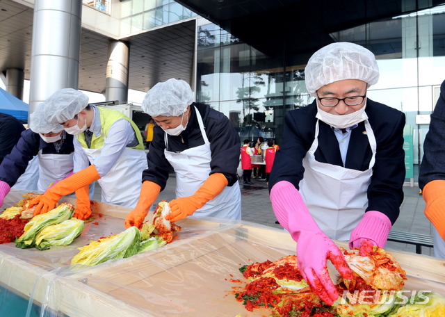 【서울=뉴시스】 지난해 금천구청 광장에서 열린 기업과 함께하는 ‘사랑의 김장 나눔’ 행사에서 유성훈 금천구청장(사진 오른쪽)이 기업 임직원과 함께 어려운 이웃에게 나눠줄 김치를 담그고 있다. (사진=서울시 금천구청) 2019.11.05. photo@newsis.com 