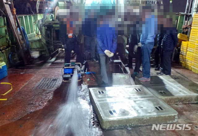 【부산=뉴시스】 6일 오후 10시 8분께 부산 서구 부산공동어시장 부두에 계류 중인 대형트롤어선 A호(139t)의 어창이 침수됐다는 신고를 받은 부산해경이 배수펌프 등을 동원해 물을 빼내고 있다. (사진=부산해경 제공). 2019.11.07. photo@newsis.com 