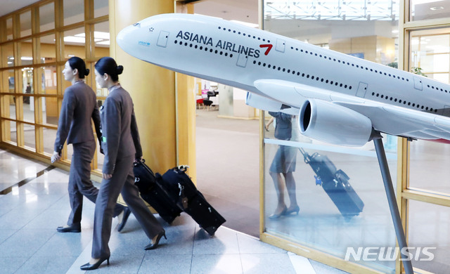 【서울=뉴시스】홍효식 기자 = 아시아나항공의 새 주인을 찾기 위한 본입찰이 진행된 7일 오후 서울 강서구 오쇠동 아시아나항공 본사 로비에 전시된 모형 항공기 뒤로 승무원들이 지나가고 있다. 2019.11.07.&nbsp; yesphoto@newsis.com