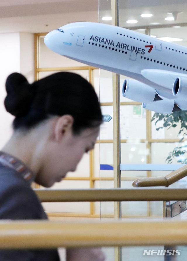【서울=뉴시스】홍효식 기자 = 아시아나항공의 새 주인을 찾기 위한 본입찰이 진행된 7일 오후 서울 강서구 오쇠동 아시아나항공 본사 로비에 전시된 모형 항공기 앞으로 승무원들이 지나가고 있다. 2019.11.07.&nbsp; yesphoto@newsis.com