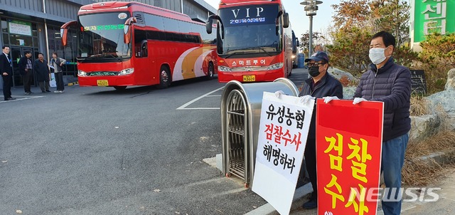 【대전=뉴시스】유성농협 조합윈들이 단체 워크숍을 떠나기 위해 버스 출발을 기다리고 있는 가운데 일부 조합원들이 검찰 조사 중인 내용에 대해 조합장의 해명을 요구하며 피켓시위를 벌이고 있다.