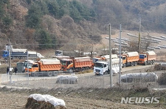 【연천=뉴시스】이경환 기자 = 지난 11일 오후 경기 연천군 중면 마거리 민통선 내 임진강 상류 마거천 주변에 마련된 살처분 매몰지에 덤프트럭들이 살처분 된 돼지 수만마리를 싣고 대기하고 있다. 2019.11.12. (사진=연천임진강시민네트워크 제공) lkh@newsis.com