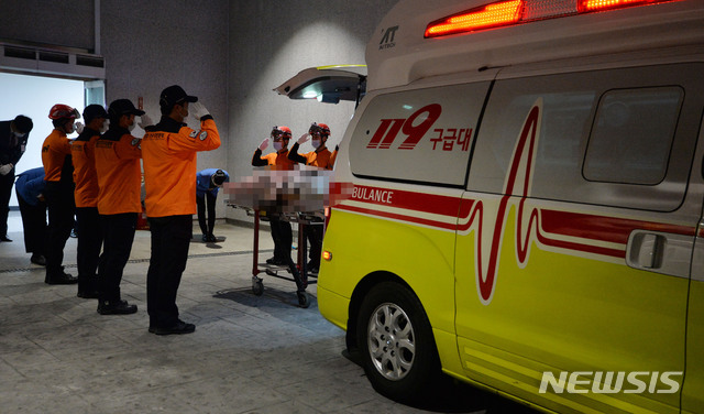 【대구=뉴시스】이무열 기자 = 12일 오후 독도 해상 소방헬기 추락사고 현장에서 수습된 실종자 시신이 대구시 달서구 계명대학교 동산병원에 도착해 119중앙구조본부 대원들이 고인에게 경례를 하고 있다. 2019.11.12. lmy@newsis.com