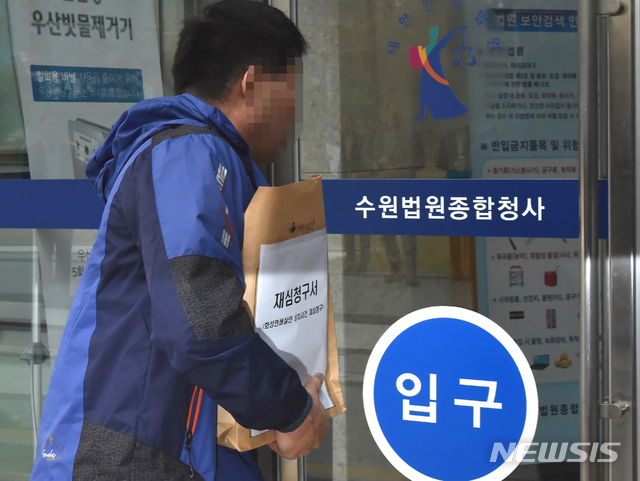 【수원=뉴시스】 김종택 기자 = 화성연쇄살인 8차 사건의 범인으로 지목돼 20년 동안 수감생활을 한 윤모(52)씨가 재심청구서를 들고 13일 오전 경기 수원시 영통구 수원지방법원으로 들어가고 있다. 2019.11.13.&nbsp; semail3778@naver.com