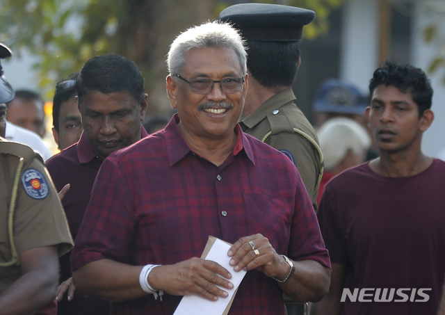 【콜롬보(스리랑카)=AP/뉴시스】16일 치러진 스리랑카 대통령선거에서 야당 후보인 고타바야 라자팍사가 콜롬보 외곽 엠불데니야의 투표소에서 투표를 마친 후 투표소를 떠나며 미소짓고 있다. 집권당 후보인 사지트 프레마다사 주택문화건설부 장관은 17일 야당 후보인 코타바야 라자팍사 후보에게 패배했다고 인정했다. 2019.11.17