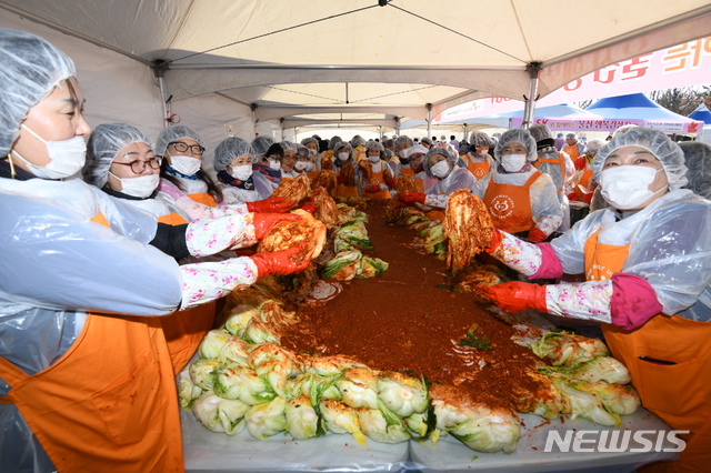 [울산=뉴시스]안정섭 기자 = 21일 울산대공원 남문 광장에서 'SK와 함께하는 울산 행복김장 데이(Day)' 행사가 개최된 가운데 자원봉사자들이 김장 김치를 담그고 있다. 2019.11.21. (사진=SK 울산콤플렉스 제공)photo@newsis.com