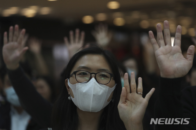 [홍콩=AP/뉴시스]21일(현지시간) 홍콩 IFC몰에서 주민들이 시위대가 요구했던 5가지 요구 사항을 의미하는 손을 펼쳐 들고 "법안 통과, 홍콩을 구하라" 등의 구호를 외치고 있다. 2019.11.21.