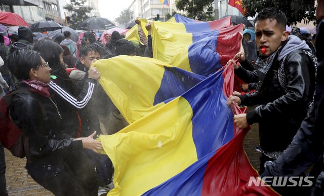 [보고타=AP/뉴시스]21일(현지시간) 콜롬비아 전역에서 파업이 일어나 보고타의 볼리바르 광장에서 대학생들이 시위 중 대형 국기를 펼치고 있다. 콜롬비아의 주요 노조와 대학생들은 이반 두케 콜롬비아 대통령의 정책에 그간 쌓였던 불만을 표출하며 시위를 벌이고 있다. 노동자들은 두케 대통령이 연금 수급 나이를 높이고, 청년 노동자의 임금을 낮추는 등 경제·노동 개혁을 준비 중이라며 반발하고 있으며 대학생들은 정부에 교육 예산 확충 등을 촉구하고 있다. 2019.11.22.