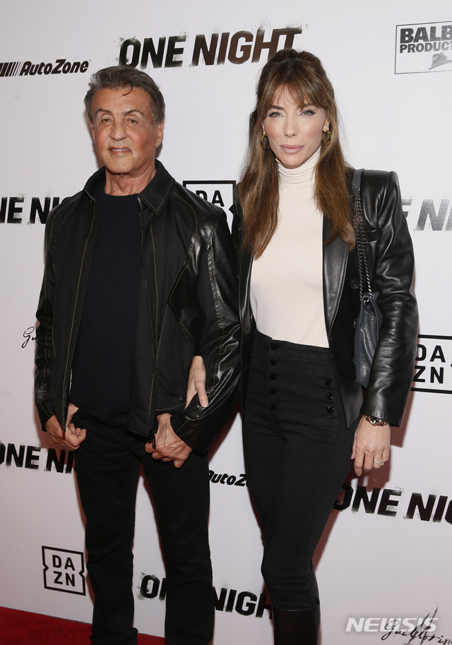 IMAGE DISTRIBUTED FOR DAZN - Executive Producer Sylvester Stallone, left, and wife and entrepreneur Jennifer Flavin, right, pose on the red carpet at the premiere of DAZN's "ONE NIGHT: JOSHUA VS. RUIZ," a documentary film from Balboa Productions and DAZN Originals at the Writers Guild Theater on Thursday, Nov. 21, 2019, in Beverly Hills, Calif. (Photo by Danny Moloshok/Invision for DAZN/AP Images)