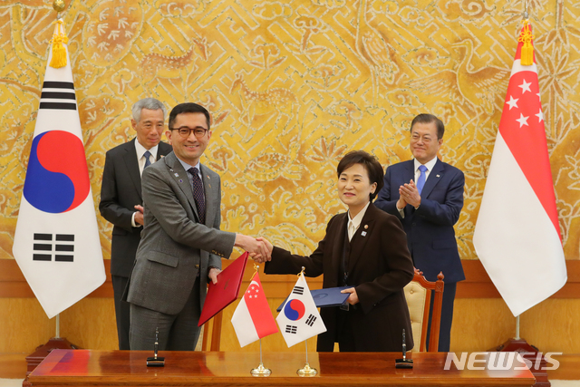 [서울=뉴시스]배훈식 기자 = 김현미 국토교통부 장관과 에릭 테오(Eric Teo) 싱가포르 주한대사 23일 청와대 본관에서 문재인 대통령과 리센룽 싱가포르 총리가 지켜보는 가운데 스마트시티 협력 MOU를 교환하고 있다. 2019.11.23.&nbsp; dahora83@newsis.com
