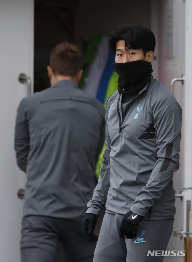 Tottenham's Son Heung-min, right wrapped up against the cold waits to start a training session for their upcoming Champions League Group B soccer match against Olympiakos at their training ground in London, Monday, Nov. 25,2019. Tottenham play Olympiakos on Tuesday. (AP Photo/Alastair Grant)