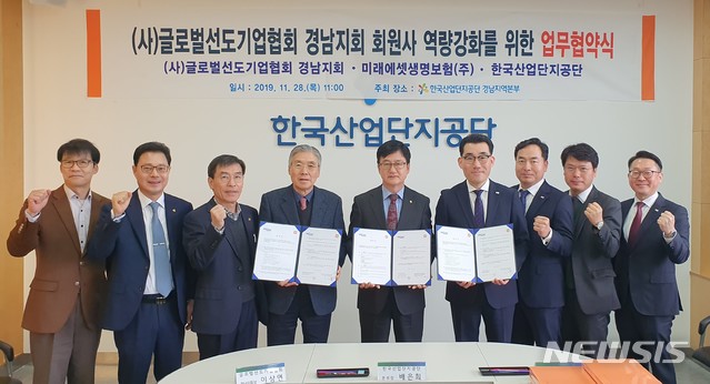 [창원=뉴시스]한국산업단지공단 배은희(가운데) 경남지역본부장과 글로벌선도기업협회 이상연(왼쪽) 경남지회장, 미래에셋생명보험 송동진 신부산 사업본부장이 28일 산단공 경남본부 6층 소통회의실에서 업무협약을 체결한 후 관계자들과 기념촬영을 하고 있다.(사진=산단공 경남본부 제공)2019.11.28. photo@newsis.com