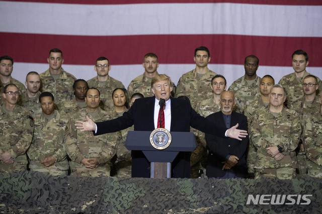 [카불=AP/뉴시스]도널드 트럼프 미국 대통령이 28일(현지시간) 추수감사절을 맞아 아프가니스탄 수도 카불 인근 바그람 공군기지 주둔 미군 부대를 깜짝 방문해 아슈라프 가니 아프간 대통령이 참석한 가운데 장병들에게 연설하고 있다. 트럼프 대통령은 이날 아프간을 찾아 아슈라프 가니 아프간 대통령과 회담하고 바그람 공군 기지에서 미군 장병들과 추수감사절 식사를 함께했다. 트럼프 대통령의 이번 아프간 방문은 안전 문제를 이유로 철저하게 비밀리에 이뤄졌다. 2019.11.29.
