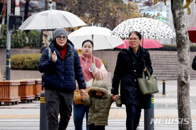 [서울=뉴시스]김병문 기자 =지난 1일 오전 서울 종로구 광화문네거리 일대에서 외국인 관광객 가족이 우산을 쓰고 있다. 2019.12.01. dadazon@newsis.com