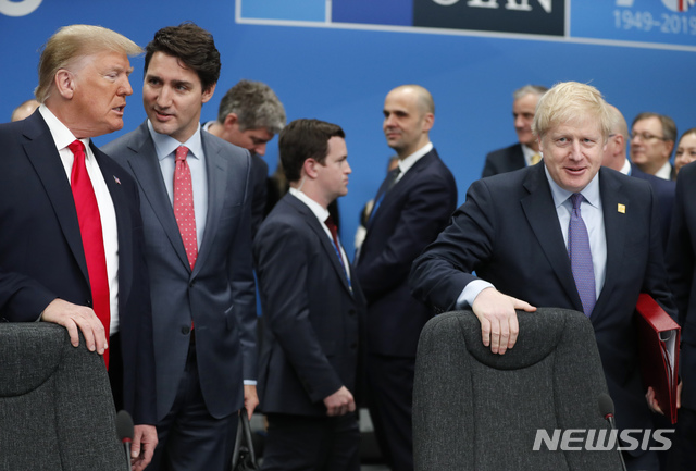 [런던=AP/뉴시스] 4일 런던 나토정상회의 정상들이 원탁회의를 위해 각자자리로 갈 때 캐나다의 쥐스텡 트뤼도 총리가 도널드 트럼프 미 대통령과 몇 마디 말을 주고받고 있다. 주최국 영국의 보리스 존슨 총리가 트럼프 옆의 중앙부 자리에 착석하려 하고 있다. 전날 영 여왕 만찬이 시작되기 전 트뤼도(48)와 존슨(54)은 프랑스대통령 마크롱(41)과 함께 나이든 트럼프(73)의 "회담 상대를 전혀 배려하지 않는 '떠버리 장광설' 기자회담 버릇"을 놓고 한참 신나게 험담을 늘어놓았던 것으로 풀 사진단의 비디오가 말해주었다. 2019. 12. 04.&nbsp; 